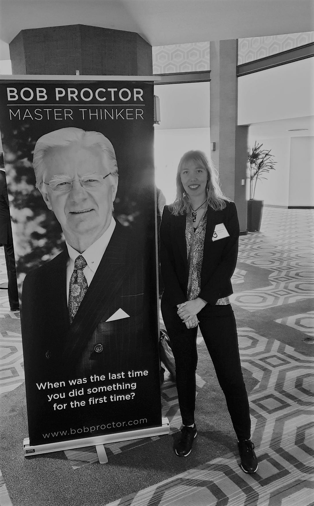 Delphine à Los Angeles, à côté de l’affiche du séminaire de Bob Proctor